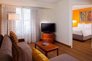 a hotel room with a couch and a tv and a bed at Sonesta ES Suites Birmingham Homewood in Birmingham