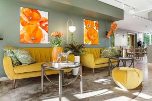 un soggiorno con divano giallo e tavoli di Best Western Hotel Danderyd a Danderyd