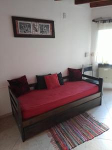 1 cama con sábanas rojas y almohadas en una habitación en Claro de luz en Federación
