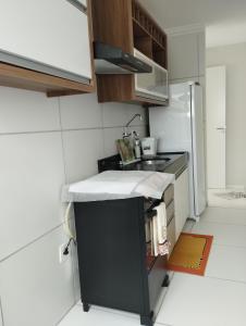 a small kitchen with a sink and a refrigerator at Apto Charmoso Bosque Heliópolis in Garanhuns