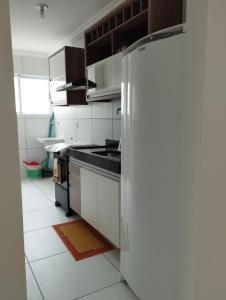 a kitchen with white cabinets and a refrigerator at Apto Charmoso Bosque Heliópolis in Garanhuns