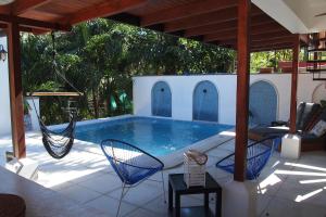 a swimming pool with a hammock on a patio at Casa Vitality Nosara in Nosara