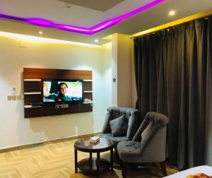 a living room with a couch and a tv on a wall at Afaq Al Raha in Khamis Mushayt