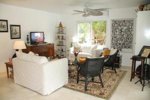 a living room with white furniture and a tv at Casa Vitality Nosara in Nosara