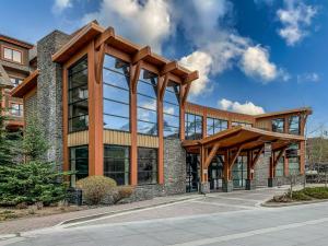 an office building with glass windows and wooden beams at Sophisticated MTN 2 Bedroom Pool Hot Tub managed by Little Sister Getaways in Canmore