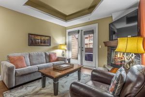a living room with a couch and a fireplace at Sophisticated MTN 2 Bedroom Pool Hot Tub managed by Little Sister Getaways in Canmore