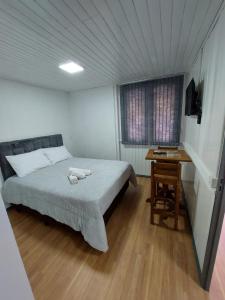 a bedroom with a bed and a table in it at Pousada Caminho do Altos in Bom Jardim da Serra