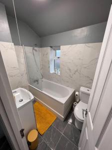 Cosy home in Rochester, sleeps 6 في Strood: حمام مع حوض ومرحاض ومغسلة
