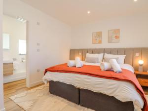 a bedroom with a large bed with an orange blanket at Bal An Mor in Penzance
