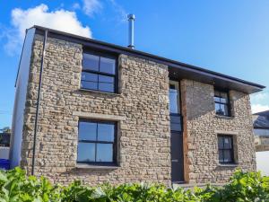 a stone house with black windows on the side of it at Bal An Mor in Penzance