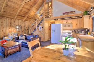 a kitchen and a living room with a table in a cabin at Alma Cloud 9 Cabin with Fireplace and Wooded Views! in Alma