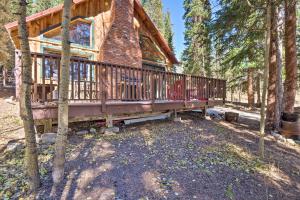 a log cabin with a large deck in the woods at Alma Cloud 9 Cabin with Fireplace and Wooded Views! in Alma