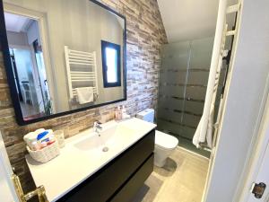 a bathroom with a sink and a toilet and a mirror at PRECiOSO ÁTICO in Majadahonda