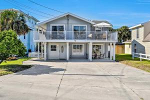 a house with a balcony on a driveway at Vilano Beach Oasis Bungalow in St. Augustine
