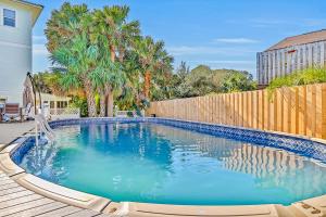 a swimming pool in a backyard with a wooden fence at Vilano Beach Oasis Bungalow in Saint Augustine