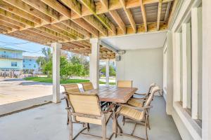 a patio with a wooden table and chairs on a porch at Vilano Beach Oasis Bungalow in Saint Augustine