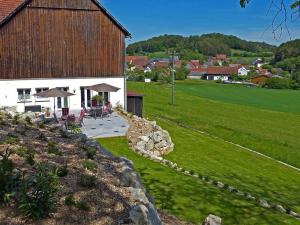 a barn with a table and chairs in a field at Landurlaub Wittmann in Pegnitz +68 photos