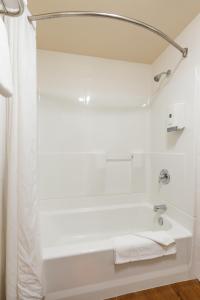 King Frederik Inn في سولفانغ: حمام أبيض مع حوض استحمام ودش