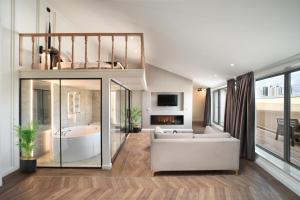 Gatto Suites&Residence في إسطنبول: غرفة معيشة مع أريكة بيضاء وحوض استحمام