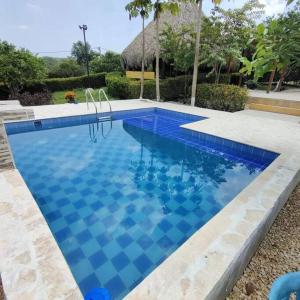 a swimming pool with blue tiles in a yard at Casa de campo en Turbaco Mi Favorita in Turbaco