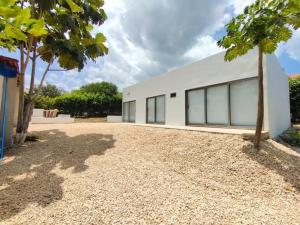 a white building with windows on the side of it at Casa de campo en Turbaco Mi Favorita in Turbaco