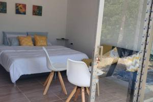 een slaapkamer met een bed en een witte stoel bij Casa de campo en Turbaco Mi Favorita in Turbaco