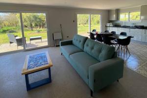 a living room with a green couch and a table at Moderna casa nueva en hermosa y soleada parcela in La Serena