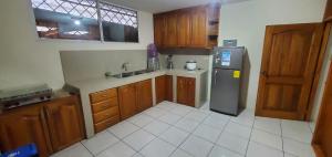 a kitchen with wooden cabinets and a stainless steel refrigerator at Departamentos extension Casa Paraíso in Manta