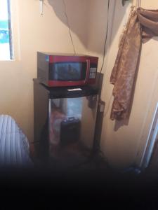 a microwave sitting on top of a table with a tv at Cocoa Cabana in Scarborough