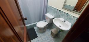 a bathroom with a toilet and a sink at Departamentos extension Casa Paraíso in Manta