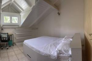 a bedroom with a white bed in a attic at l'escale des roches gravées in Trois-Rivières