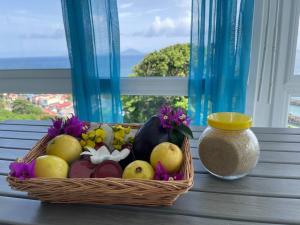 a basket of fruit on a table next to a vase at l'escale des roches gravées in Trois-Rivières