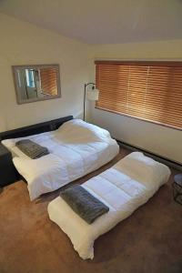 two beds in a bedroom with a window at Sunday River Ski In Ski Out Mountain View Condo with Hot Tub Pool and Sauna! in Newry
