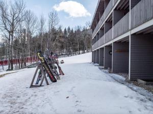 a group of skis parked next to a building in the snow at Sunday River Ski In Ski Out Mountain View Condo with Hot Tub Pool and Sauna! in Newry