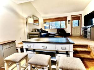 a kitchen and living room with a table and chairs at Sunday River Ski In Ski Out Mountain View Condo with Hot Tub Pool and Sauna! in Newry