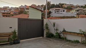 a fence with a wooden gate in a city at Estalagem Alejandro in Cunha