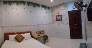 a bedroom with two beds and a table in it at Ngan Giang Guesthouse in Phu Quoc