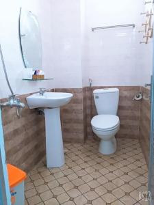 a bathroom with a toilet and a sink and a mirror at Ngan Giang Guesthouse in Phú Quốc
