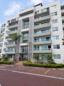 un edificio de apartamentos con un aparcamiento enfrente en Acogedor y moderno loft con vista a la ciudad, en Guayaquil