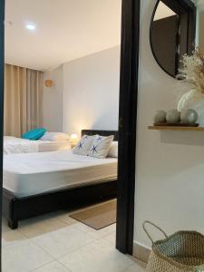 a bedroom with two beds and a mirror at Tu Apartamento en Coronado in Chame