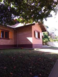 a brick house with a lawn in front of it at Cantinho da Serra in Santo Antônio do Pinhal