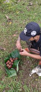 a person with a knife and a bunch of vegetables at Tegal Jero Homestay in Jatiluwih