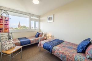 a bedroom with two beds and a window at 18 Undercliffe in Felixstowe