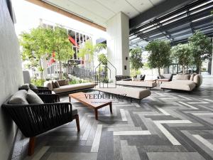 a lobby with couches and tables in a building at Lucentia Residences BBCC at Lalaport Kuala Lumpur by Veedu Hauz in Kuala Lumpur