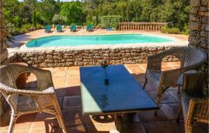 a table and chairs next to a swimming pool at 6 Bedroom Amazing Home In Entrecasteaux in Entrecasteaux +27 photos