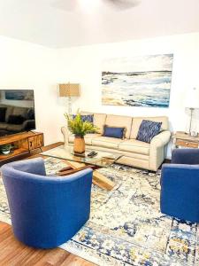 a living room with a couch and blue chairs at The Bromeliad at Turtle Cove Villas in Kiawah Island