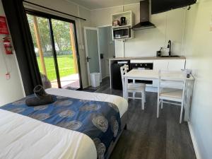 1 dormitorio con 1 cama y cocina con mesa en Marlo Caravan Park & Motel en Marlo