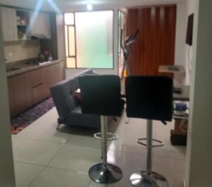- un salon avec deux chaises et un canapé dans l'établissement Linda habitación amplia iluminada Bogota Calle 80, à Bogotá