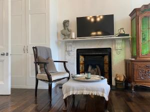 sala de estar con silla y chimenea en Alfred Road en Londres