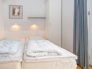a bedroom with two beds with white sheets at 6 person holiday home in H jer in Højer